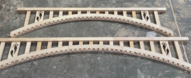 Timber arch - a pair of fretwork arch panels with dentil detail on the workshop floor