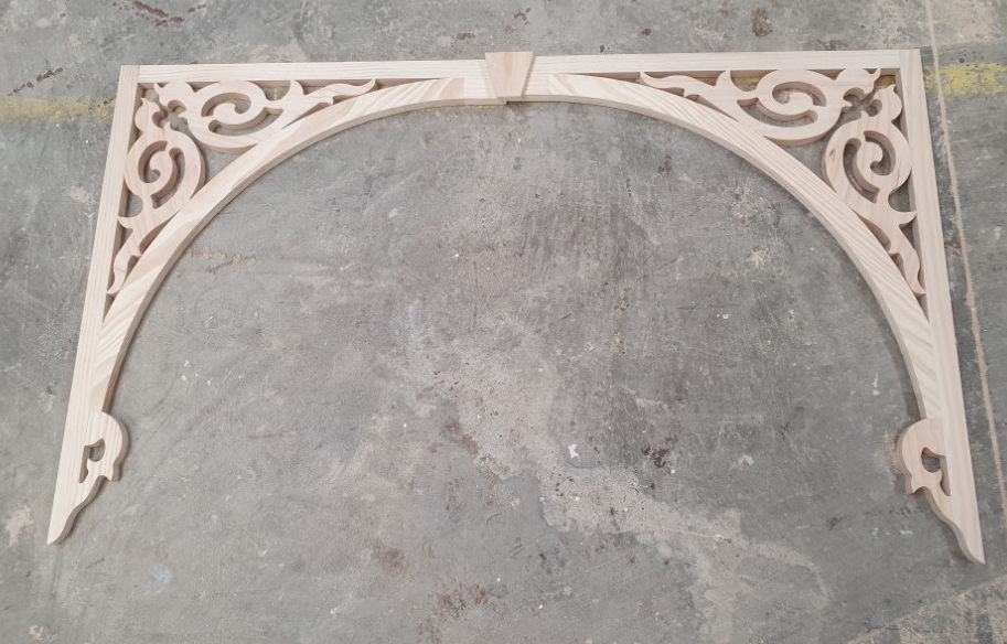 Timber arch - scrolled fretwork arch panel laid out on the workshop floor