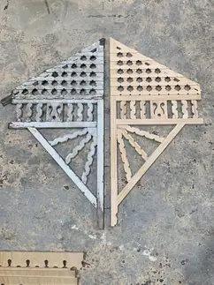 A weathered original timber bracket laid beside the new reproduction made to match it