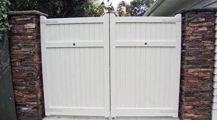 Emerald timber gate, pair of boarded gates between rough stone piers