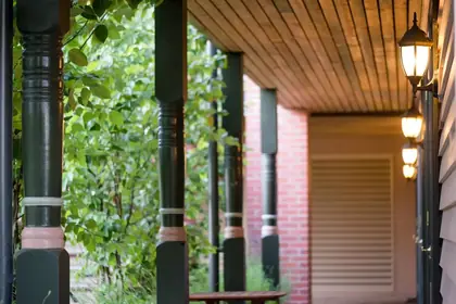 Turned timber verandah post - turned posts and lamp along a timber-lined verandah