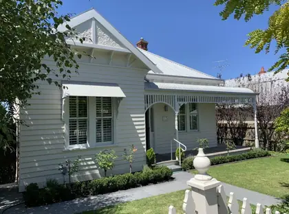 Turned timber gable finial - turned finial on a gate pier in front of a weatherboard house