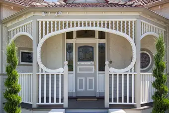 Heritage decorative timber - arched verandah brackets and balustrade on a rendered facade