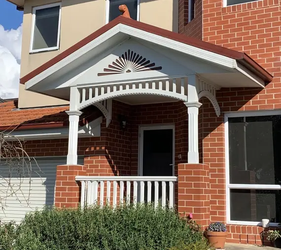 Heritage decorative timber - fan bracket and balustrade on a red brick porch
