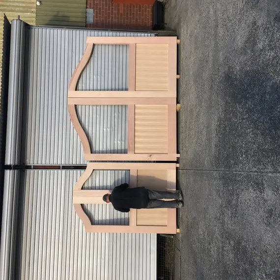 Oversized bespoke timber gates shown at full workshop scale.