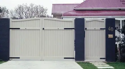 Moss timber gate, cream gates hung between dark rendered piers