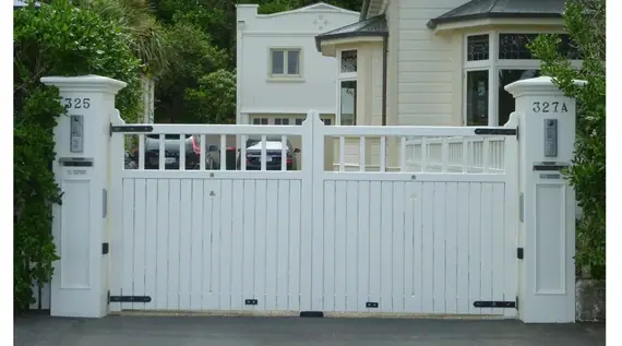 Timber driveway gates - white boarded gates with a slatted top, hung between rendered piers