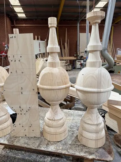 Newly turned timber gable finials on the workshop bench, beside the dimensioned setting-out template