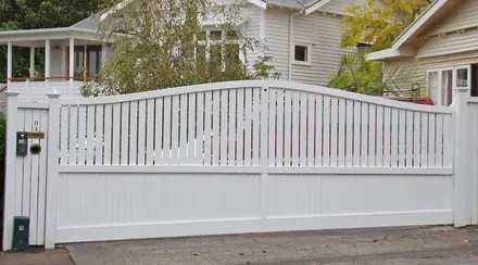 Cleve timber gate, curved-top driveway gate hung at a weatherboard house