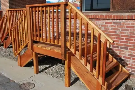 Timber balustrade BS6, square balusters on deck steps against a brick wall