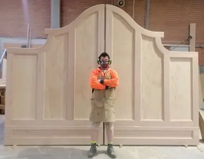 Tall panelled timber gates with a shaped arched head, in the Heritage workshop
