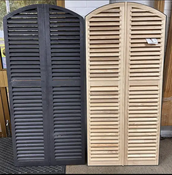 A painted and natural pair of arched timber louvre doors.