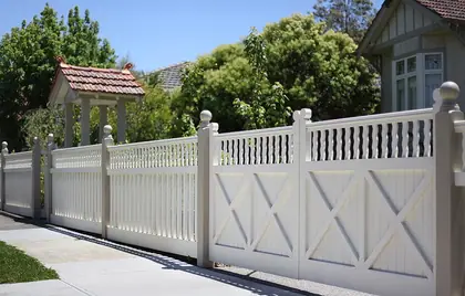 White timber boundary fence with a spindle top rail and matching entry gates