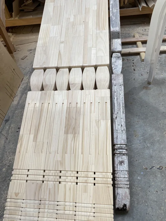 Weathered painted post alongside new shaped and fluted timber reproductions