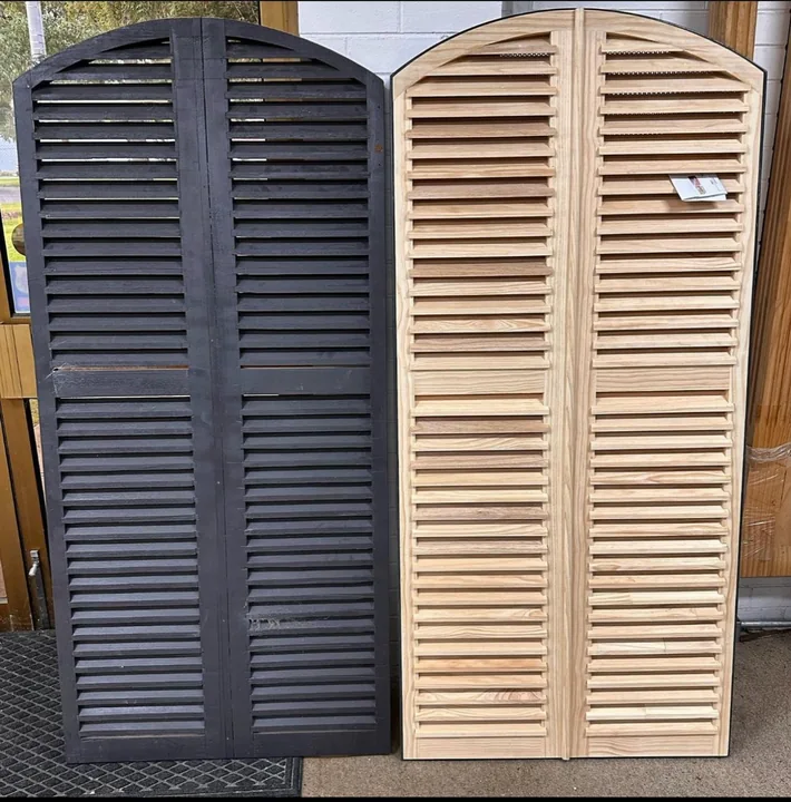Painted arched window shutters beside matching unpainted timber louvre shutters