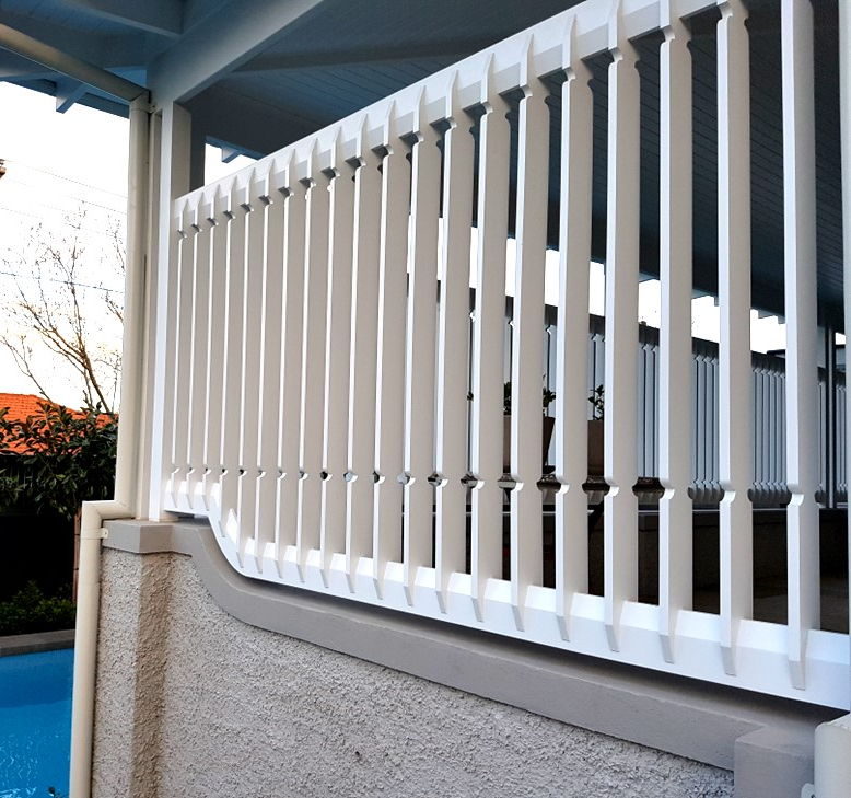 White painted timber balustrade installed along a rendered wall beside a pool
