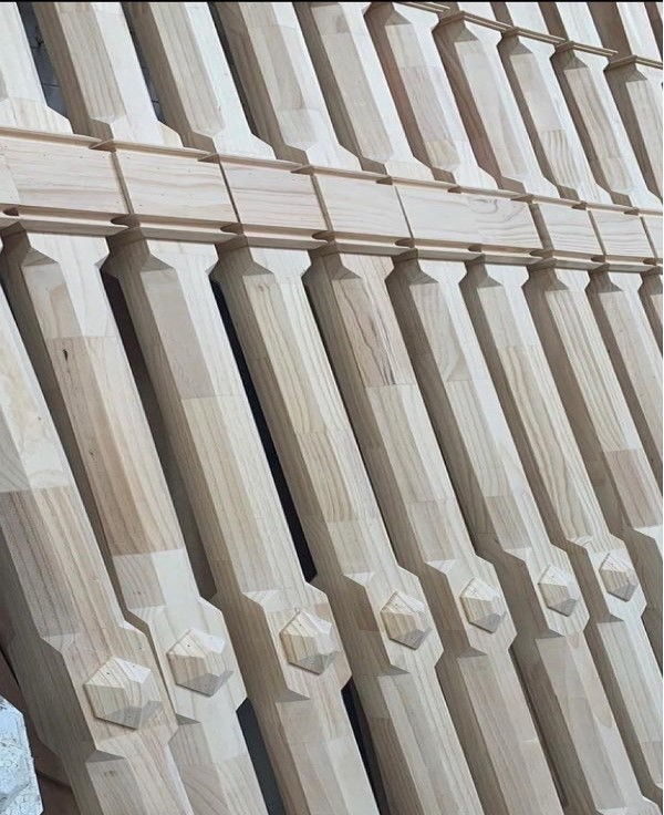 Close-up of machined timber balusters stacked in the workshop