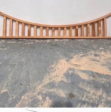 Curved unpainted balustrade panel made to follow a bowed opening