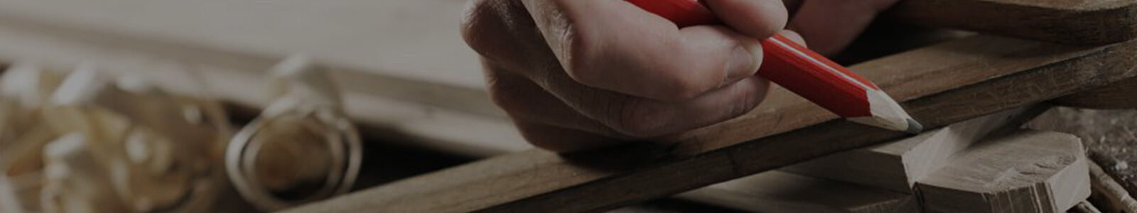 Banner crop of a hand marking out a timber length with a red carpenter's pencil