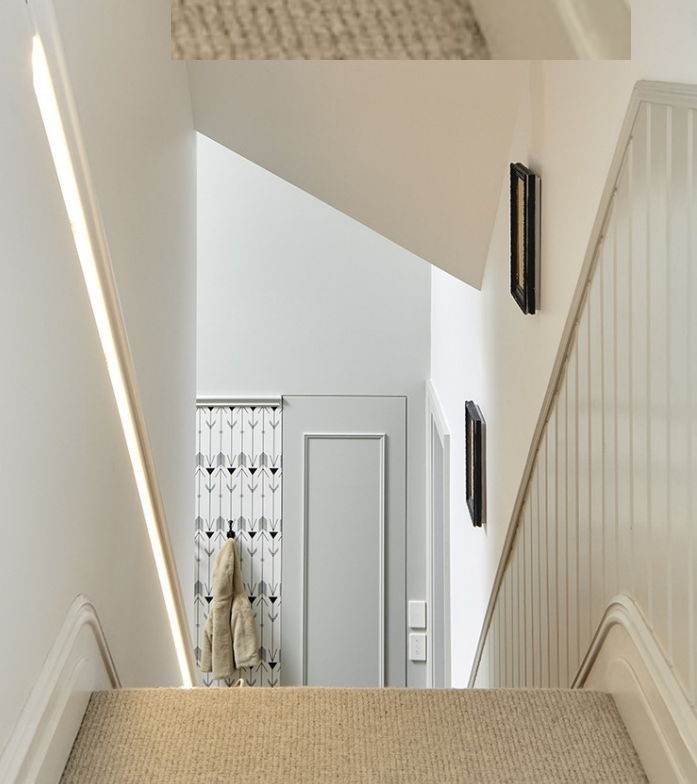 Finished internal staircase looking down into a carpeted hallway