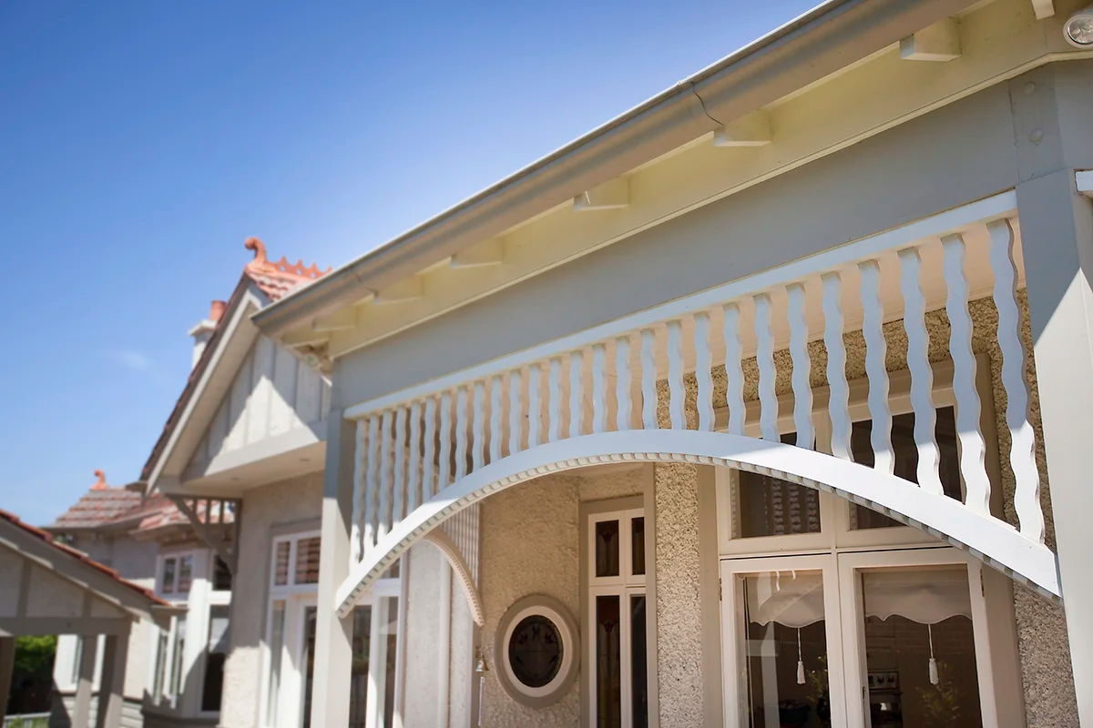 Arched fretwork running the length of a verandah under a terracotta tiled roof