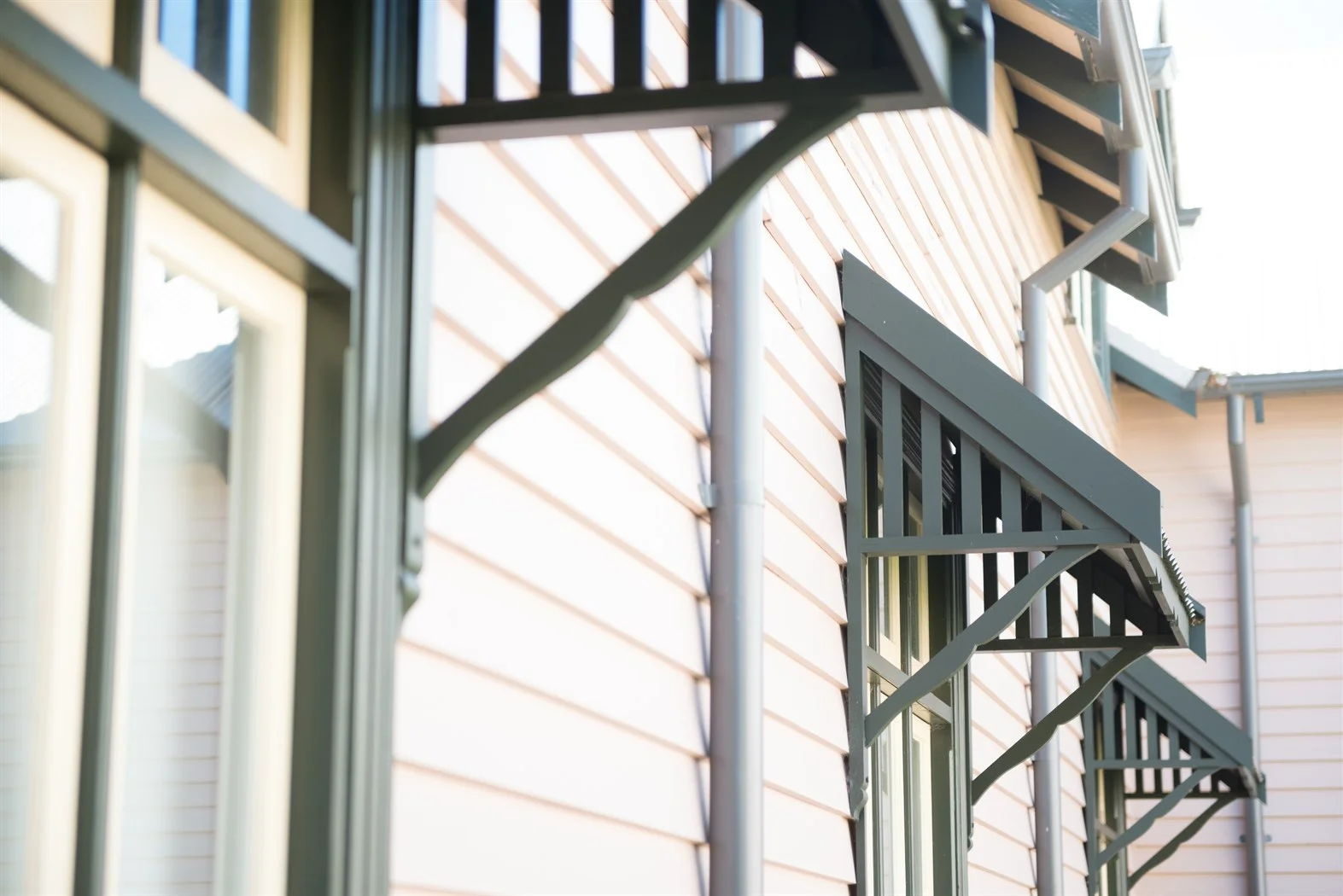 Decorative timber - timber window canopy on a painted weatherboard wall